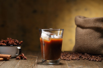 caffe' nero o americano con ghiaccio in bicchiere di vetro sfondo rustico