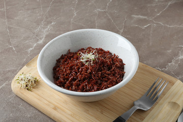 Bowl of boiled brown rice served on table