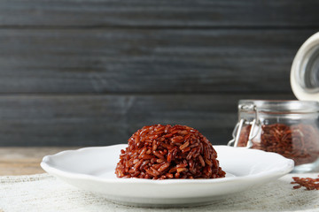 Plate of boiled brown rice on table. Space for text