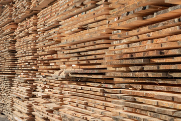 A pile of boards in a carpentry shop. Wood prepared for production in an industrial plant. Light background.