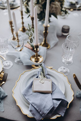 banquet table is decorated with plates, cutlery, glasses, candles and flower arrangements