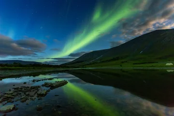 Fototapeten aurora borealis in night sky cut  mountains, reflected in  water. © Igor Dmitriev