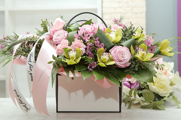 A beautiful bouquet of flowers in the box with a ribbon the inscription 