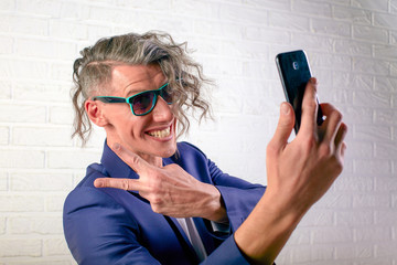 manager or businessman with stylish curly hair in white t-shirt on white background make selfie on...