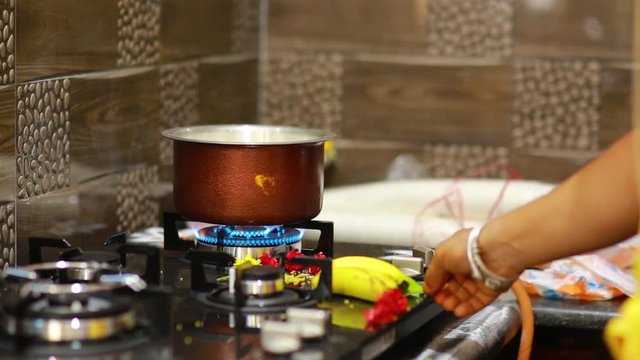 A kitchen during the Boiling the Milk for the Indian Traditional House Warming ritual. Flat plane. Eye level shot. Zoom in