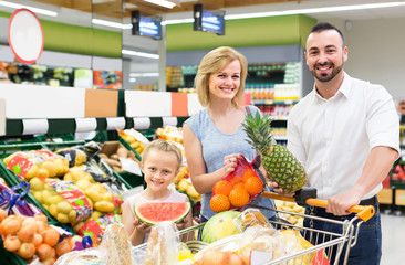 family shopping various fresh fruits in supermarket