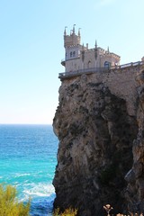 Fototapeta na wymiar View of The Swallow's Nest. It's s a decorative castle located at Gaspra in Crimea. It was built between 1911 and 1912, on top of the 40-metre (130 ft) high Aurora Cliff, in a Neo-Gothic design.