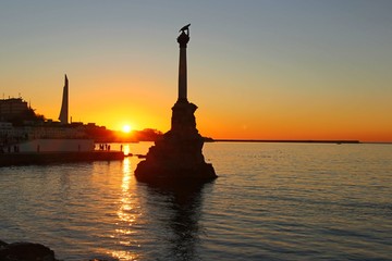 Embankment in the center of Sevastopol during sunset. In the rays of the setting sun, the Monument...