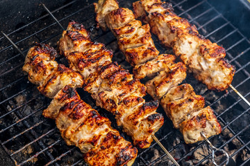 Traditional shashlik cooking on a grill isolated