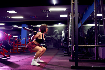 Fototapeta na wymiar beautiful sporty sexy woman doing squat workout in gym