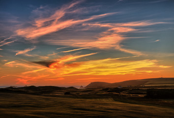 Blick über einen Golfplatz auf Constantine Bay nach Sonnenuntergang