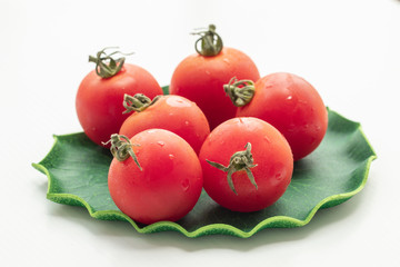 Close up tomatoes in green leaf on isolate white background.Selective focus red tomatoes.