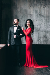 Portrait of the bride and groom. Red dress and black suit.