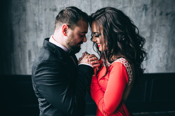 Portrait of the bride and groom. Red dress and black suit.
