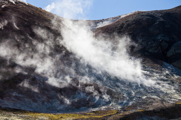 Iceland geothermal zone - area in mountains with hot springs. Cracks in mountains with hot steam.Tourist and natural attractions.