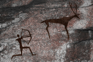 The image on the wall of the cave of an ancient hunter and animal . ancient history.