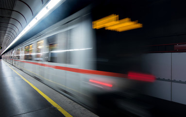 blur of moving light trail of train in subway and passenger at platform for transportation in business city of Europe