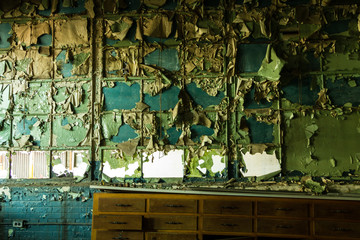 Peeling paint of windows with old desk in an abandoned factory