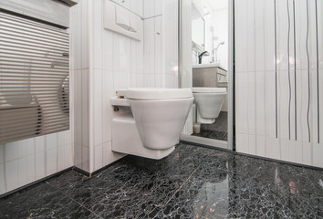 The photo of the white toilet bowl hanging on a wall in the hotel toilet room