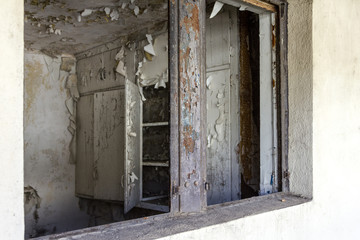 Looking through opening into kitchen in a long abandoned housing project apartment building