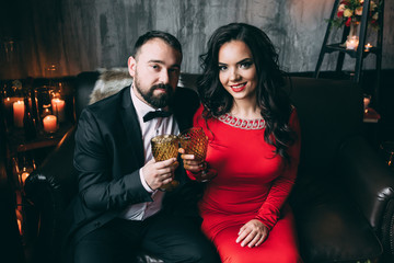 Photo session of the newlyweds in the studio. Red dress and black suit.
