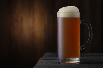 Mug of beer on wood background
