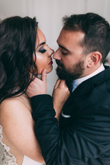 Portrait of the bride and groom. A passionate kiss.