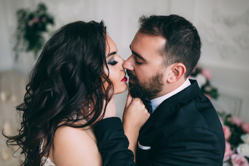 Portrait of the bride and groom. A passionate kiss.