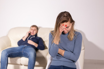 domestic violence, abuse and family concept - crying woman and her husband on the background