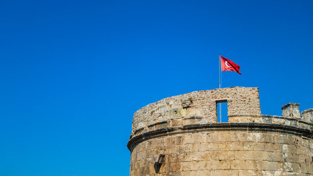 Hidirlik Tower with the turkish flag waving on the wind. Shoot in Antaya, Turkey.
