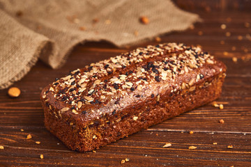 Whole wheat craft bread on wooden background. The concept of healthy food and traditional bakery. Rustic