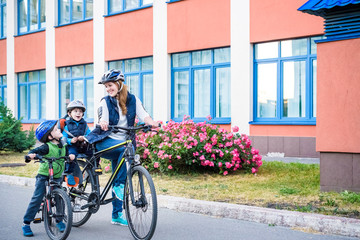 Obraz premium Family cycling, mother with happy kid riding bike outdoors