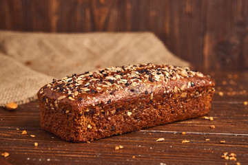 Whole wheat craft bread on wooden background. The concept of healthy food and traditional bakery. Rustic