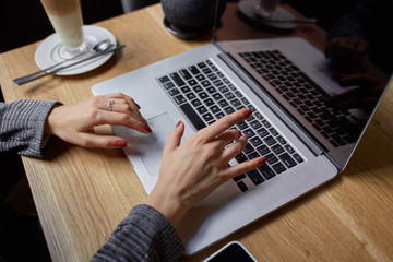 Lifestyle education student. Businesswoman work on laptop for project. Millennial at home office drink coffee looking for job on notebook. Unrecognizable woman using modern portable computer and phone