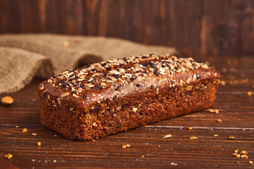 Whole wheat craft bread on wooden background. The concept of healthy food and traditional bakery. Rustic