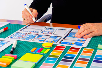 ux The graphic designer is working on a model of the future mobile application. Designer sketches the future concept of a web application.