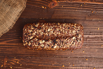 Whole wheat craft bread on wooden background. The concept of healthy food and traditional bakery. Rustic