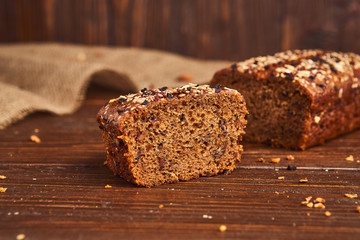 Whole wheat craft bread on wooden background. The concept of healthy food and traditional bakery. Rustic