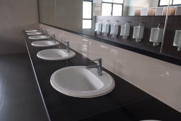 White urinals and sink in men's bathroom