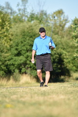 Unemotional Male Golfer With Golf Club On Golf Course