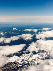 beautiful clouds from above with sow covered mountains © woitzel