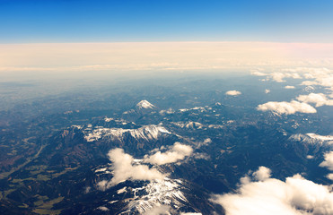 beautiful clouds from above with sow covered mountains © woitzel