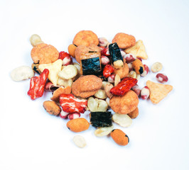 Mix of Asian snack on white background. Including Nori Maki Arare rice crackers in seaweed, glaze peanuts and fried crackers. Close up.