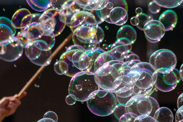 Farbenfroh schillernde Seifenblasen leuchten und glitzern im Sonnenschein