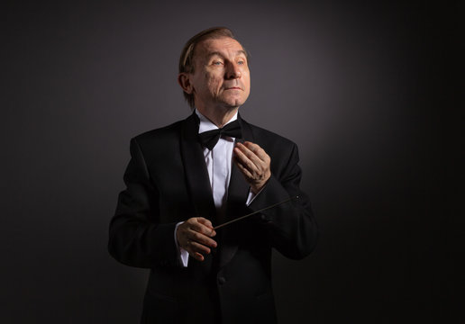 Emotional portrait of the conductor gesticulating with his hands on a light background.