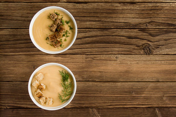 pea soup with croutons and greens on a wooden background