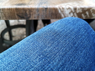 Blaue Oberfläche einer Blue Jeans aus blauem Denim in Nahaufnahme in einem Café in der Altstadt von Bielefeld im Teutoburger Wald in Ostwestfalen-Lippe