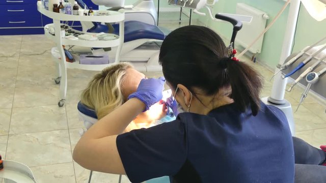 Kiev, Ukraine - April 2019: Girl at the reception at the dentist. Dentist treats teeth to the patient in the dental office. The dentist treats the patient in the clinic.