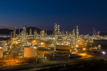 Aerial view. Oil refinery factory and oil storage tank at twilight and night. Petrochemical Industrial.