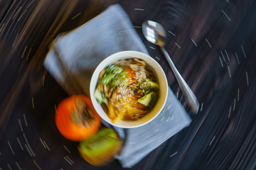 Top View of the Oatmeal with Fresh Persimmon, Kiwi, Walnut and Sesame. Abstract Blured in a Circular Motion Colorfull Food Background